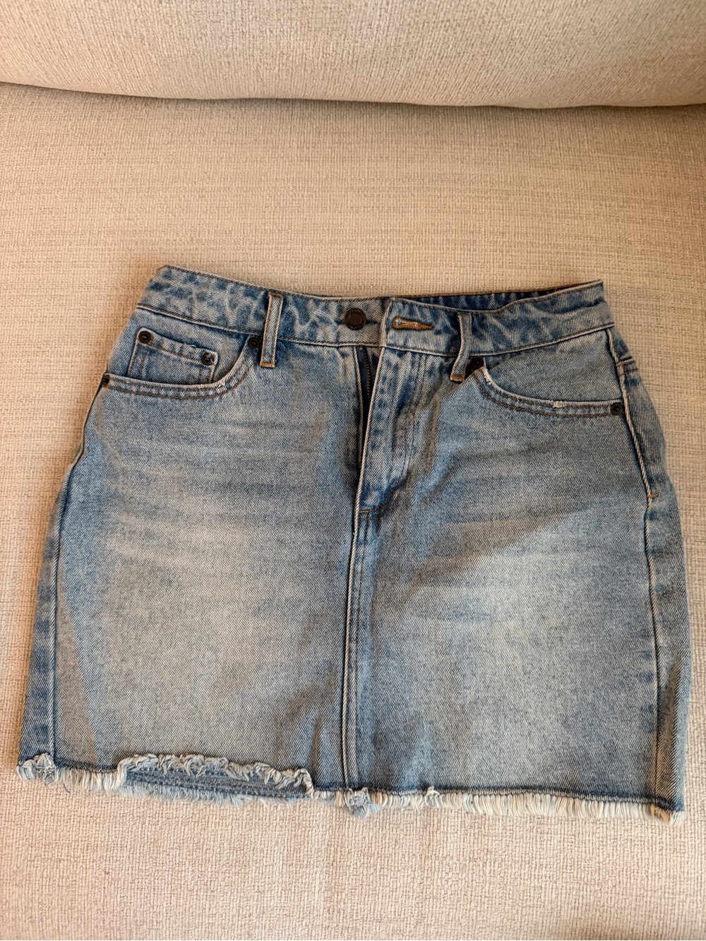 Kittenish faded light blue denim mini skirt with frayed hem